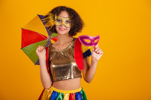 Bella donna brasiliana vestita con abiti frevo vestiti per il carnevale con ombrello colorato e maschera di carnevale