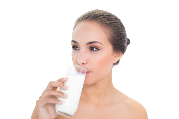 Bella donna bruna bere un bicchiere di latte