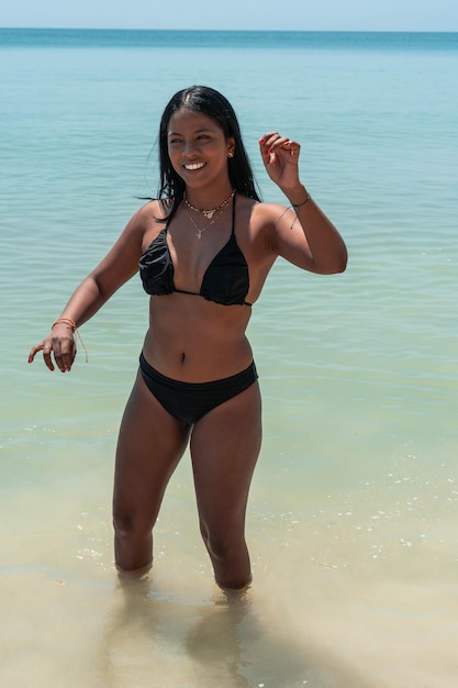 Bella donna bruna che si diverte in una spiaggia