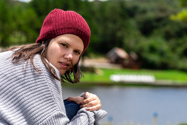 Bella donna bruna con un cappello nel parco