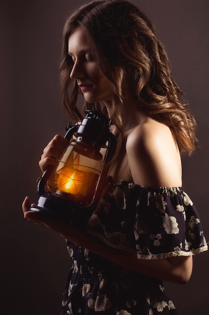 Bella donna bruna con una lampada accesa al buio