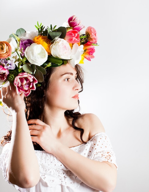 Bella donna capelli castani con ghirlanda di fiori sulla sua testa. Moda di bellezza. Primavera donna