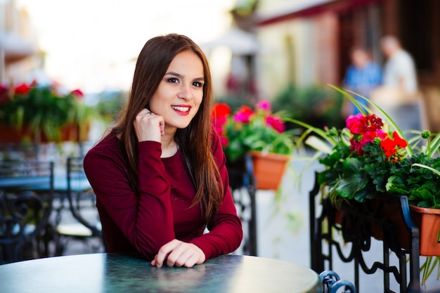 Bella donna castana che si siede in un caffè a Parigi