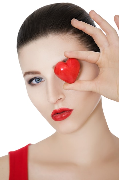 Bella donna castana che tiene cuore rosso davanti al viso. San Valentino