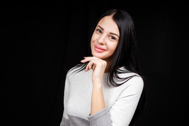 Bella donna castana in un vestito grigio