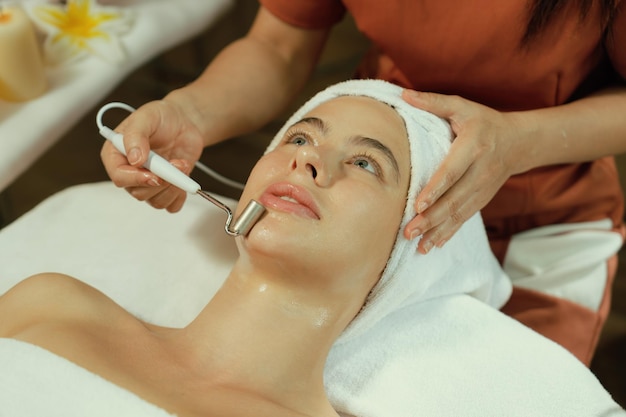 Bella donna caucasica che fa un massaggio facciale alla spa Close Up Tranquility