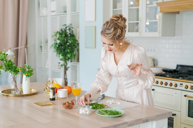 Bella donna caucasica che prepara insalata fresca fragole mature e rucola