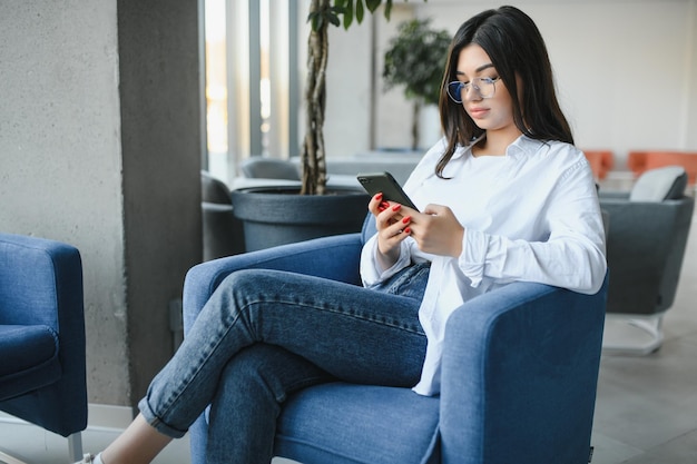 Bella donna caucasica che sogna qualcosa mentre si siede con un netbook portatile nel moderno bar caffetteria giovane affascinante freelance femminile che pensa a nuove idee durante il lavoro sul computer portatile