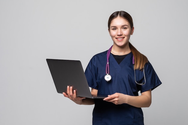 Bella donna caucasica medico o infermiere in possesso di un computer portatile isolato su un bianco