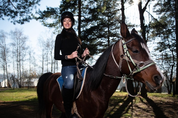 Bella donna cavalca un cavallo che indossa un casco