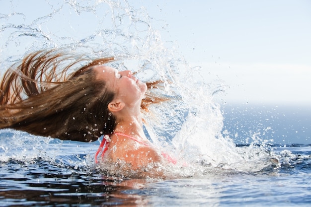 Bella donna che alza la testa fuori dall&#39;acqua