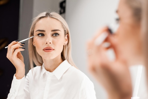 Bella donna che applica il mascara