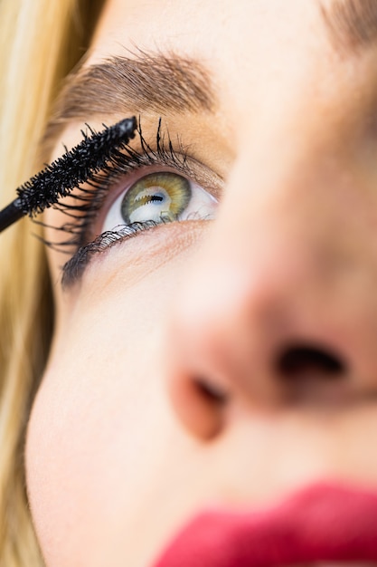 Bella donna che applica mascara sulle ciglia