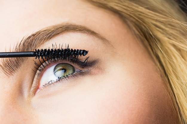 Bella donna che applica mascara sulle ciglia