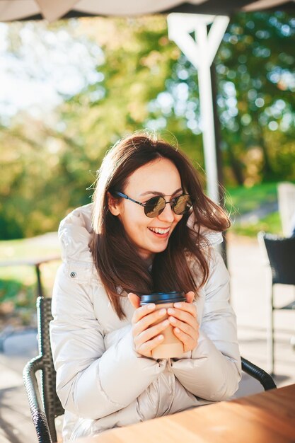 Bella donna che beve caffè nella caffetteria all'aperto