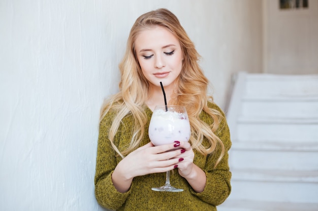 Bella donna che beve cocktail al ristorante