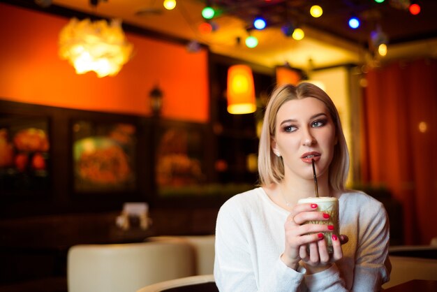 Bella donna che beve un cappuccino in un caffè