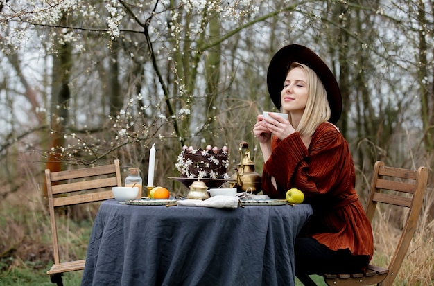 Bella donna che beve un tè in un giardino