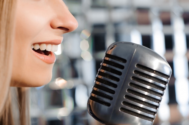 Bella donna che canta sul palco accanto al microfono.