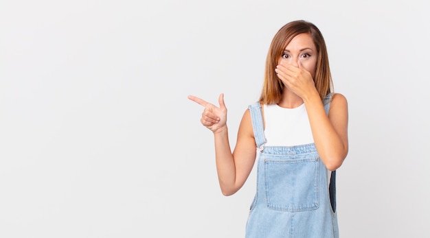 Bella donna che copre la bocca con le mani con uno spazio scioccato e una copia a lato