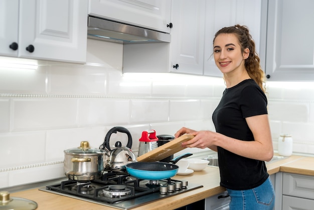 Bella donna che cucina nella cucina moderna