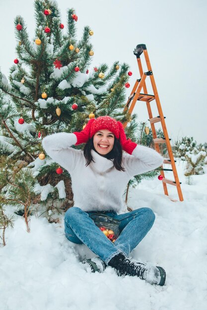 Bella donna che decora l'albero di Natale all'aperto