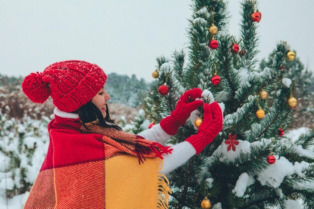 Bella donna che decora l'albero di Natale all'aperto