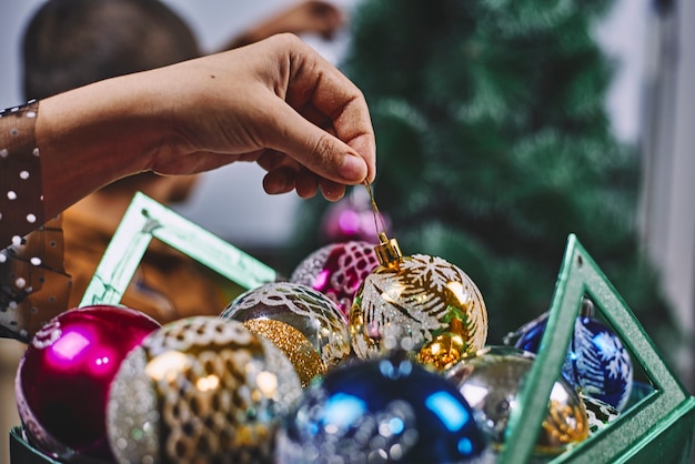 Bella donna che decora l'albero di Natale con il suo bambino.