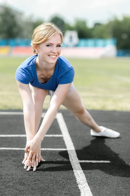 Bella donna che fa allenamento di base in uno stadio