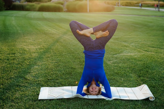 Bella donna che fa esercizi di yoga nel parco