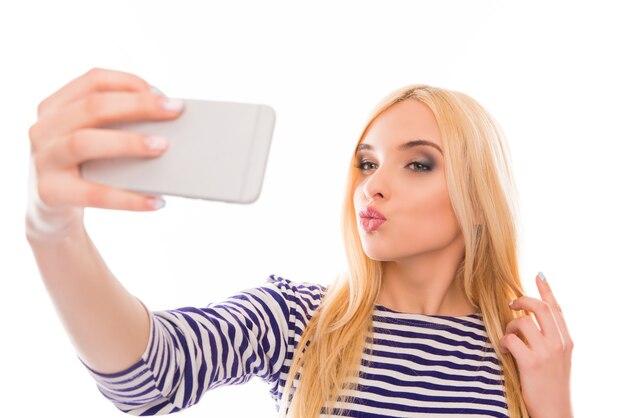 Bella donna che fa selfie sul suo smartphone e imbronciato