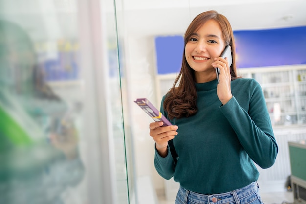 Bella donna che fa una chiamata con lo smartphone mentre tiene in mano gli accessori del cellulare