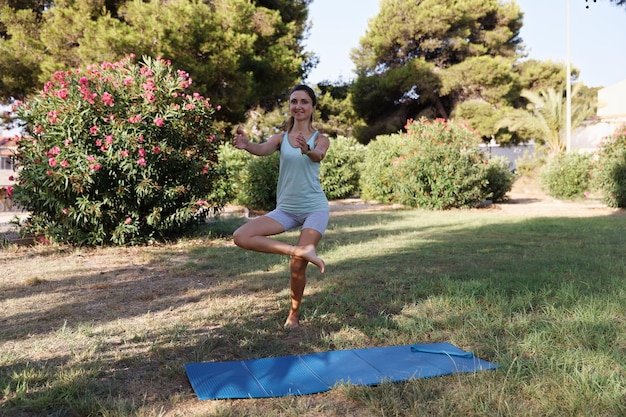 Bella donna che fa yoga nel parco mattutino Stile di vita sano concezione all'aperto Sport Donna natura ritratto facendo esercizi Stile di vita sano