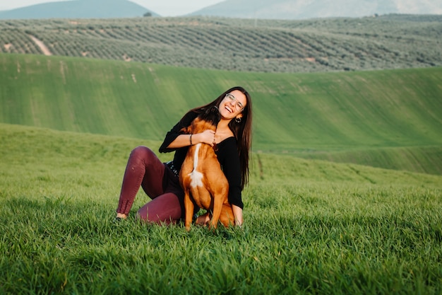 Bella donna che gioca con il suo cane. Ritratto all'aperto.