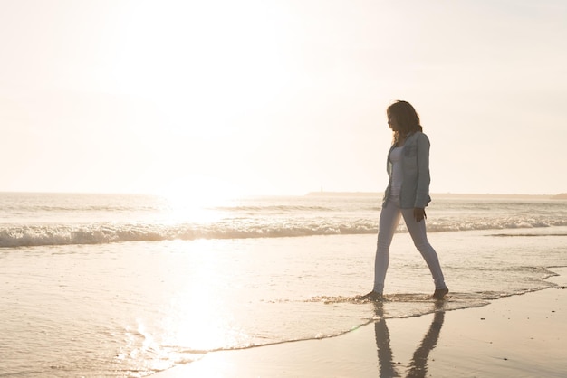 Bella donna che gode del tramonto sulla spiaggia