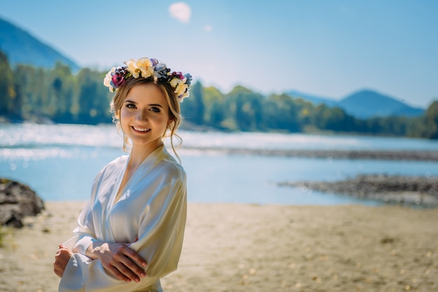 Bella donna che indossa abito bianco e ghirlanda di fiori