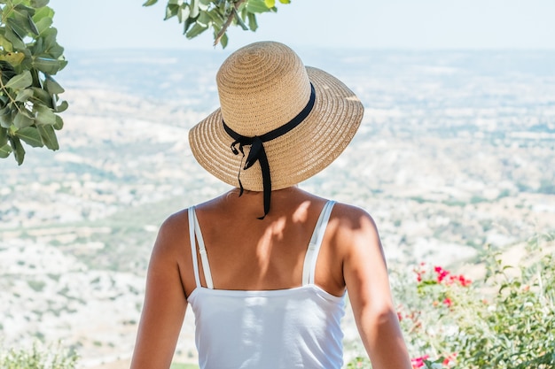 Bella donna che indossa il cappello di paglia guardando fuori