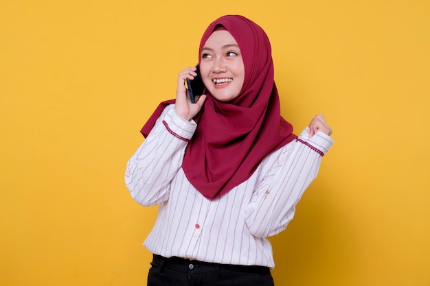 Bella donna che indossa l'hijab parlando utilizzando il telefono cellulare sorridente e allegro