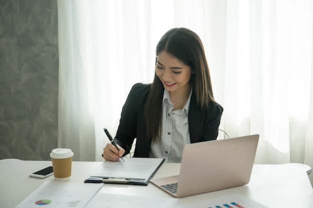 Bella donna che lavora al suo posto di lavoro in ufficio