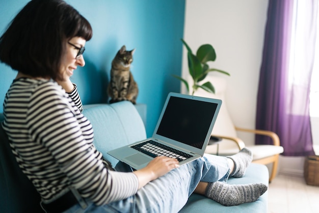 Bella donna che lavora su un laptop a casa Schermo nero sul laptop Tecnologia freelance