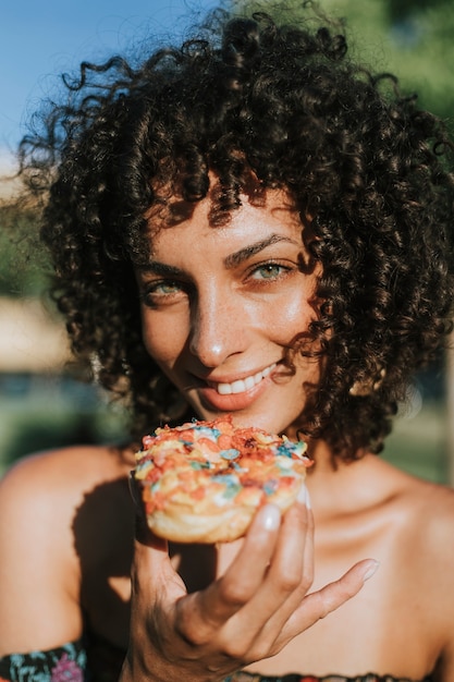 Bella donna che mangia una ciambella