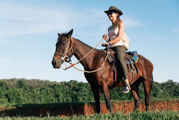 Bella donna che monta un cavallo nella campagna.