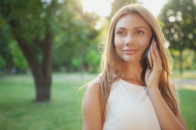 Bella donna che parla al telefono all'aperto