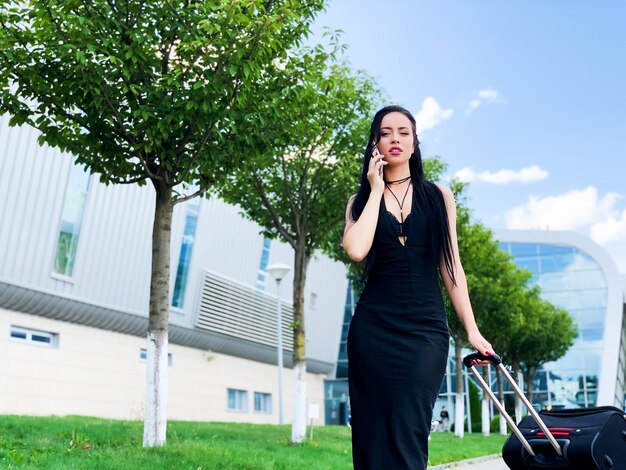 Bella donna che parla al telefono vicino all'aeroporto.