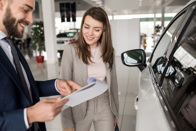 Bella donna che parla con rappresentante nel Car Showroom