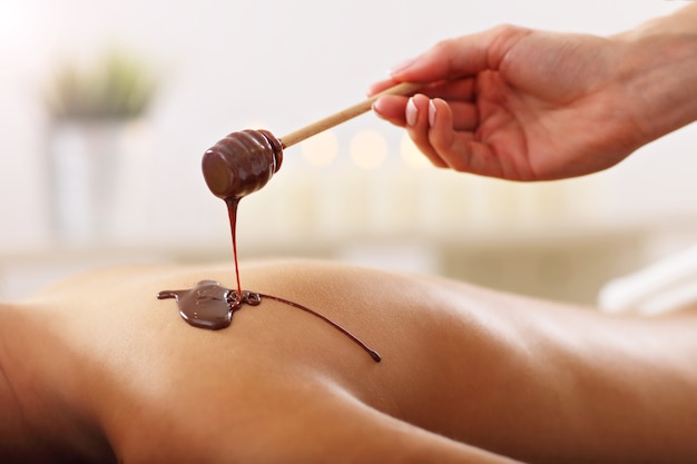 bella donna che riceve un massaggio al cioccolato nella spa?