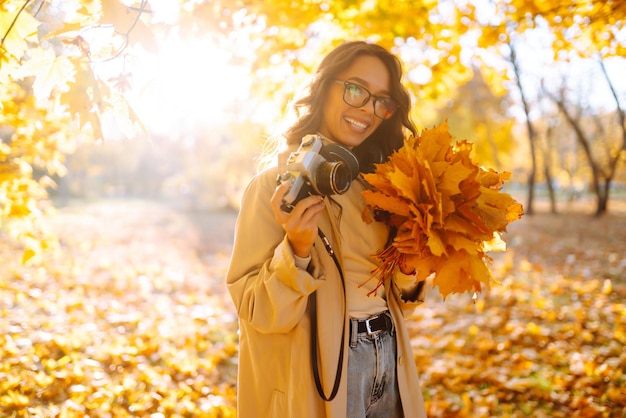 Bella donna che scatta foto nella foresta autunnale Concetto di stile di vita turistico e relax