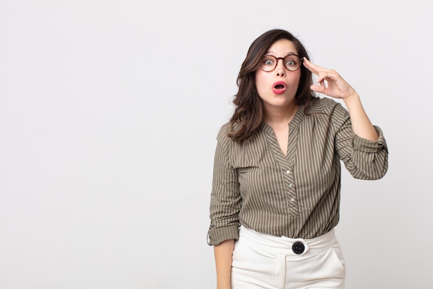 Bella donna che sembra sorpresa, a bocca aperta, scioccata, realizzando un nuovo pensiero, idea o concetto