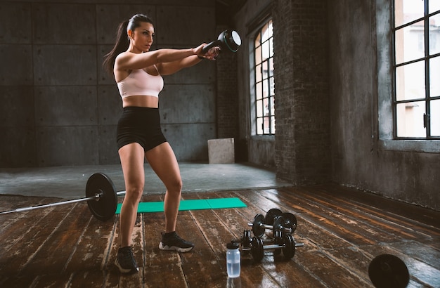 Bella donna che si allena e fa un allenamento funzionale in palestra