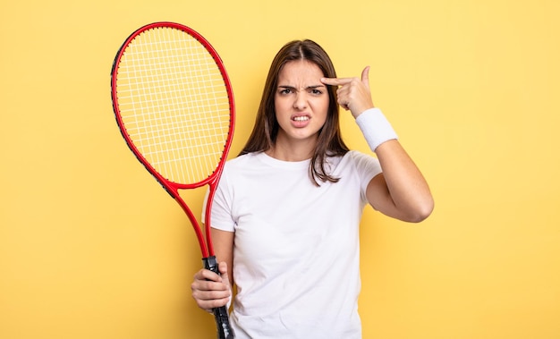 Bella donna che si sente confusa e perplessa, mostrando che sei pazzo. concetto di tennista